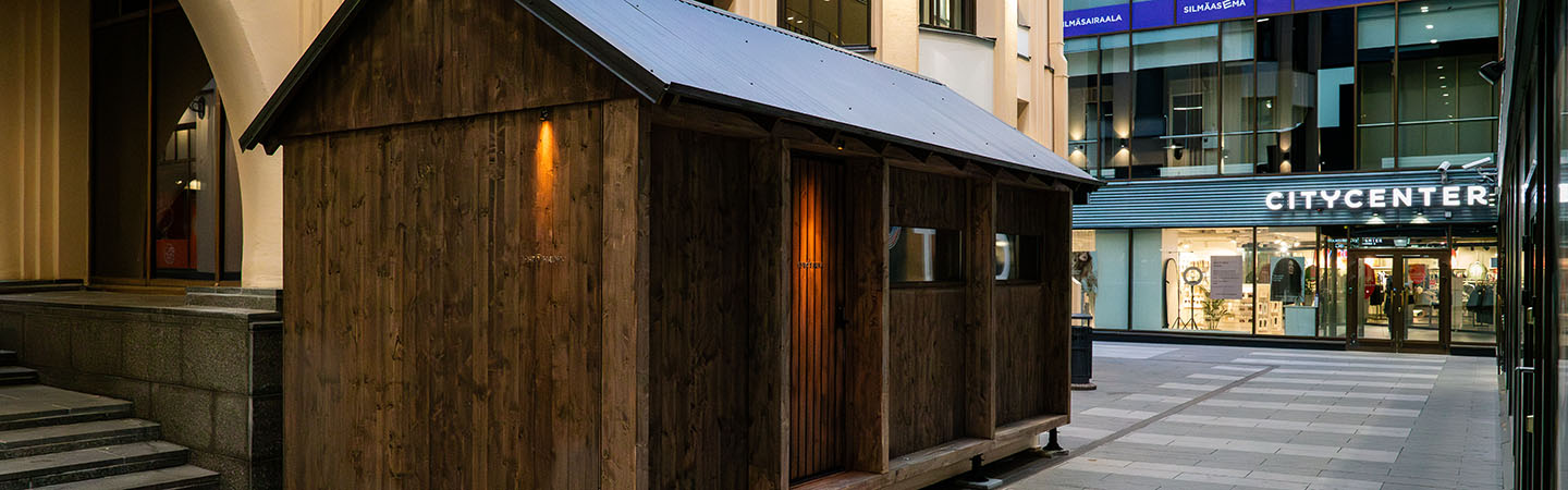 Wooden Kyrö sauna building in a shopping alley in Helsinki